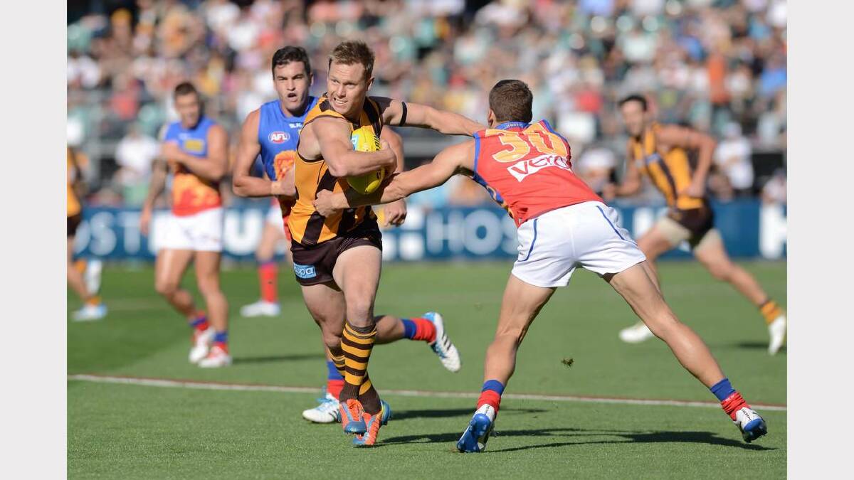 Hawthorn's Sam Mitchell breaks through a Brisbane tackle. Picture: Scott Gelston