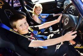 Zane, 8, and Shakiah Roney, 7, of George Town get comfortable in a 1999 Mitsubishi Lancer Evo VI. Picture: Scott Gelston