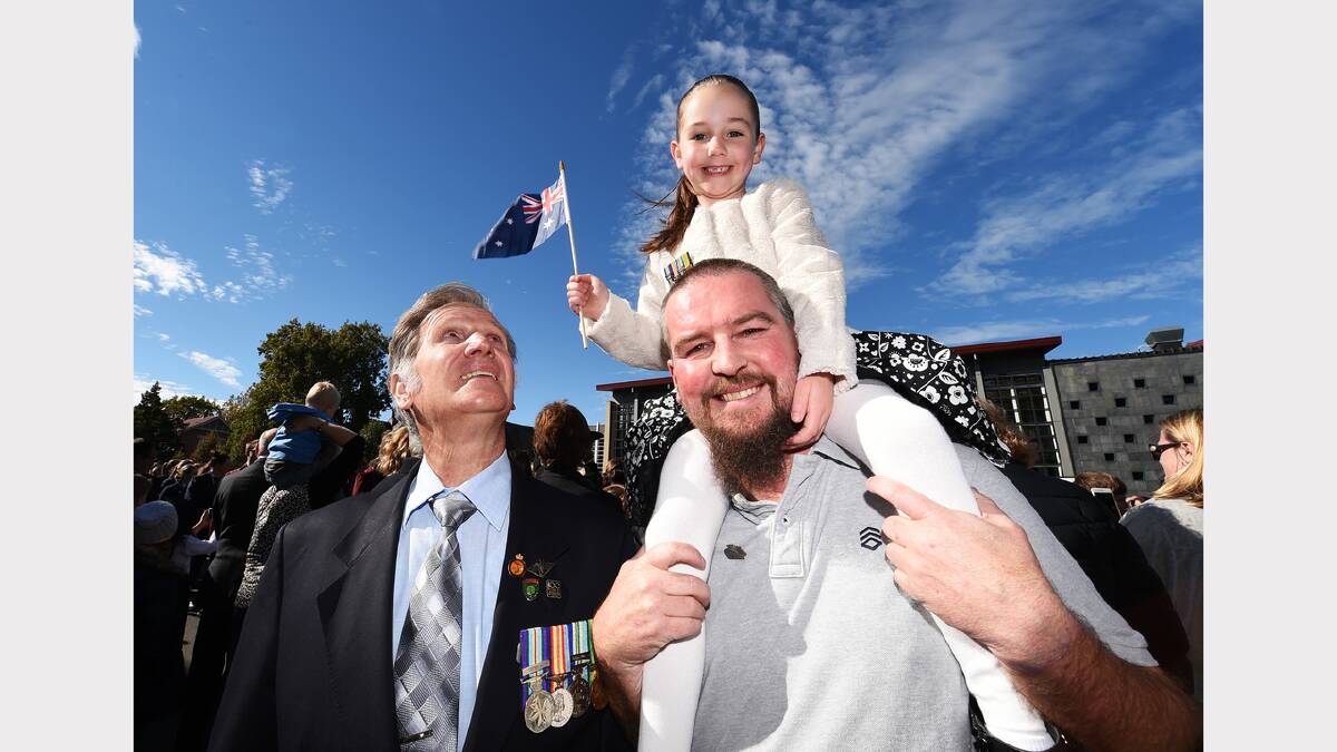 Veteran Des Taylor watches the Launceston parade with Darren and Addison Campbell, 6.