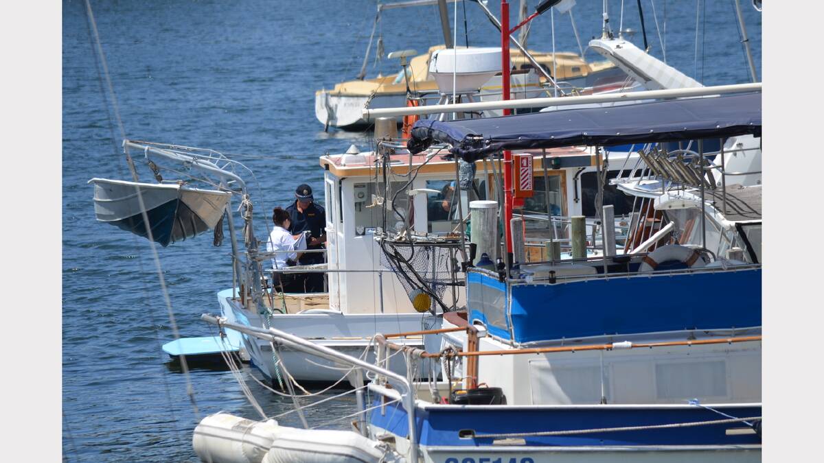 Police conduct investigations on board the boat where two men were found dead at the Prince of Wales Bay marina. Picture: ADAM LANGENBERG