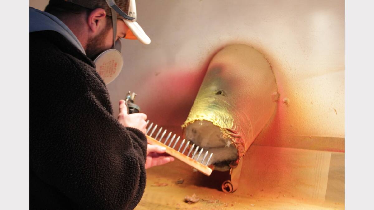 Tillins Fishing owner Scott Grey painting metal lure cores at his Blackwall workshop. Picture: Alex Druce