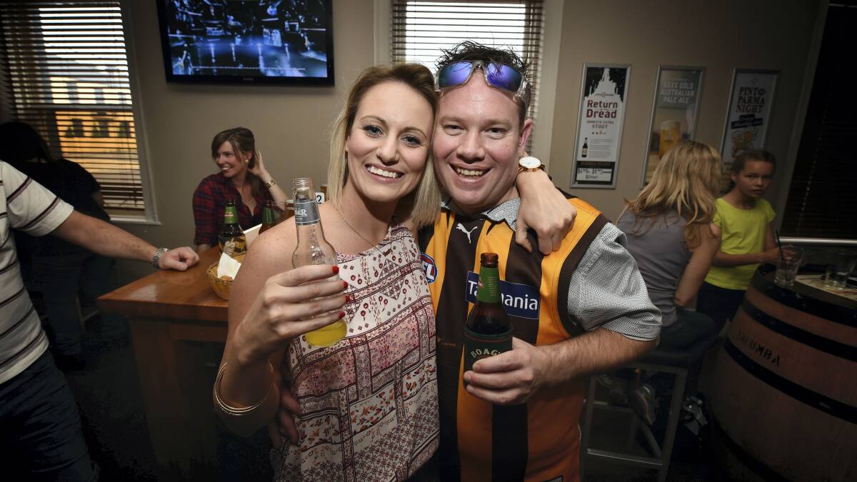 Sarah Lowe and Nic Green, both of Launceston, celebrate at the Sporties Hotel  as the Hawks extend their grand-final lead. Picture: SCOTT GELSTON