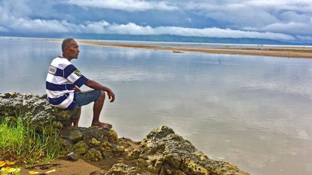 Sailosi Ramatu looks over the sea at his old village Vunidogoloa in Fiji. Each time the ocean surged through their coastal Fijian village, residents would use rafts to move from house to house.  Photo: AP
