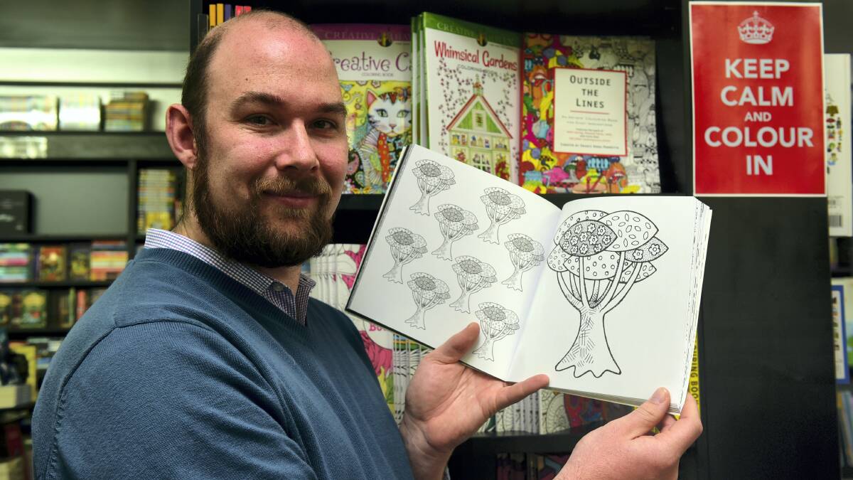 Petrarch’s Bookshop manager Marcus Durkin with one of the store’s popular adult colouring books.  Picture: PAUL SCAMBLER