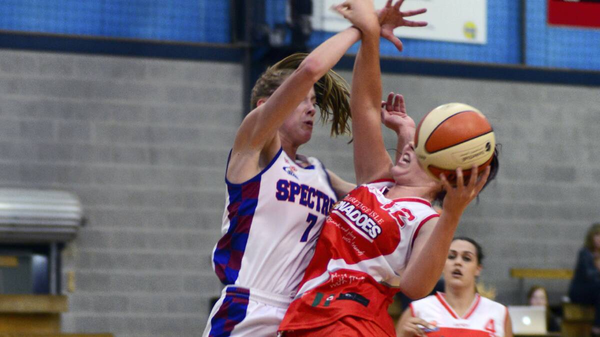 The Nunawading Spectres' Louise Brown applies a heavy  block on Tornado Nadeen Payne in yesterday's clash at the Elphin Sports Centre. Pictures: PHILLIP BIGGS.

