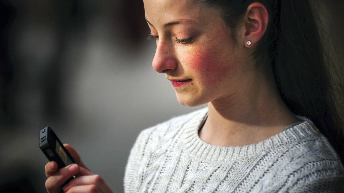 Twelve-year-old Mia Schuemaker, of Riverside, sends a text to a friend. Picture: PHILLIP BIGGS