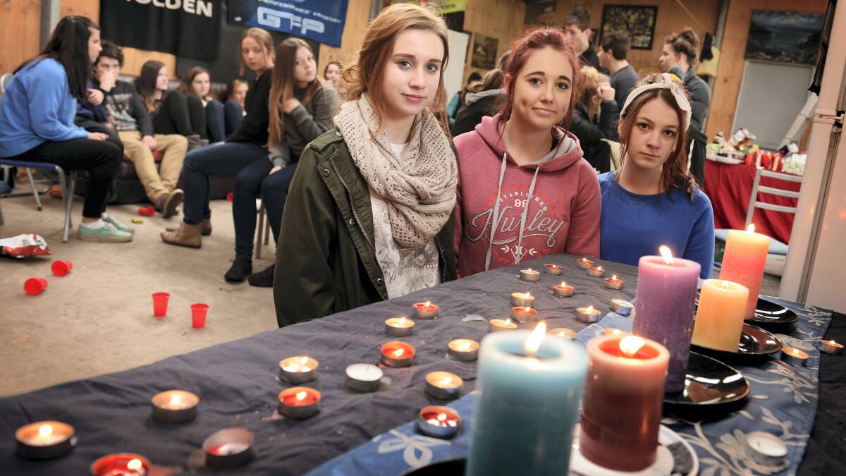 Friends of Brittany Goss Shania Price, Ellen Butt  and Taylah Ransom in front of the candle memorial.  Pictures: SCOTT GELSTON