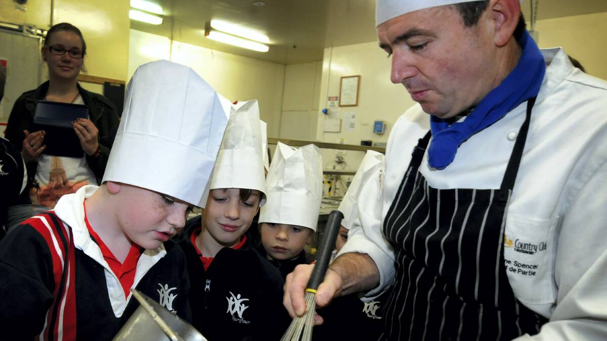 Youngtown Primary School pupils Connor Dransfield, 8, Jordan Cassidy, 8, and Alexia Crowe, 6, learn the science behind food at Country Club Tasmania with chef Shane Spencer. Picture: GEOFF ROBSON