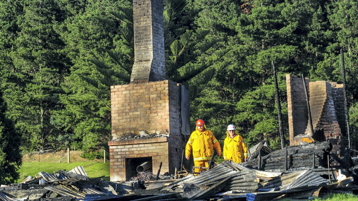 Lebrina Fire Brigade chief Karl Robbers and firefighter Terry Robbers inspect the remains of a house at Lebrina that caught fire yesterday morning. Picture: PHILLIP BIGGS