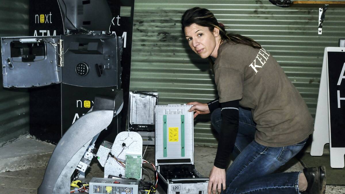 Tasmania Zoo manager Rochelle Penney inspects the destroyed automatic teller machine. Picture: NEIL RICHARDSON
