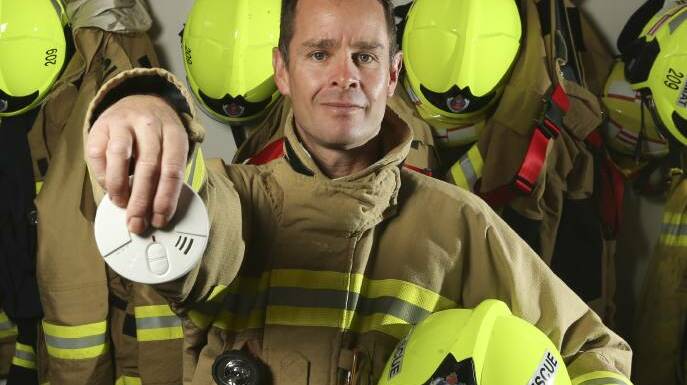 EXPIRED: NSW Fire and Rescue member Paul Bladwell holds a ionisation smoke alarm, recommended to be replaced with photoelectric. Picture: ELENOR TEDENBORG
