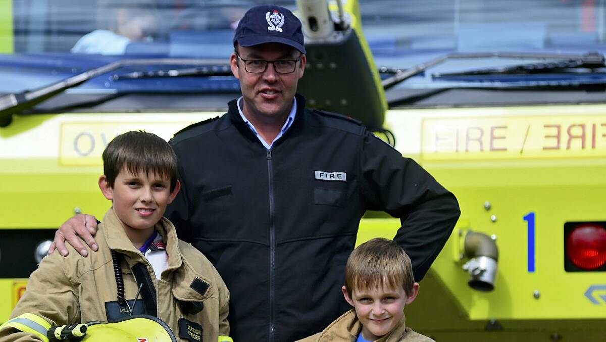 Brad Woolley, 11, and brother Mason, 8, with aviation firefighter Will Swan.  Pictures: PHILLIP BIGGS
