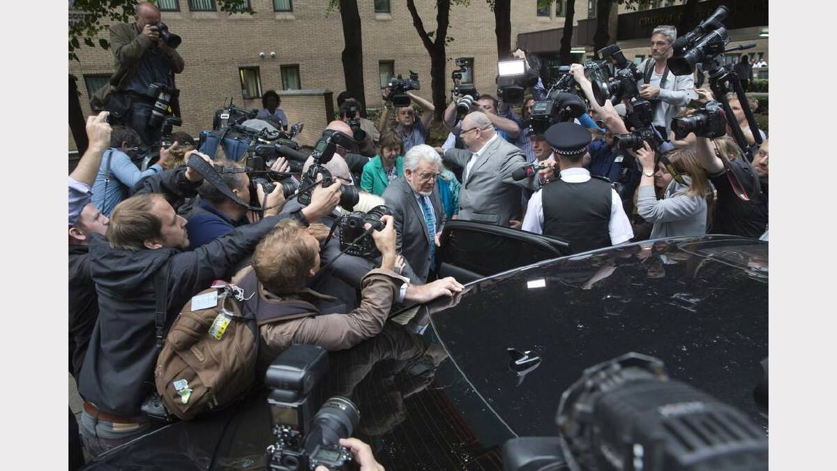 Entertainer Rolf Harris is surrounded by the media as he leaves Southwark Crown Court in London.  Harris, a mainstay of family entertainment in Britain and Australia for more than 50 years, was found guilty on Monday of 12 charges of indecently assaulting young girls over a period of nearly 20 years. Photo: REUTERS