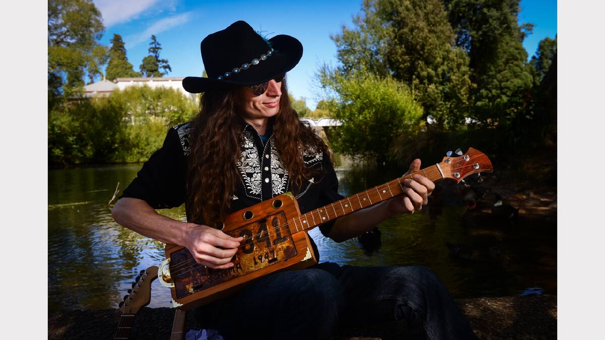 Guitarist “The Wizard” Justin Johnson beside the Meander River at Deloraine. Photo by Phillip Biggs