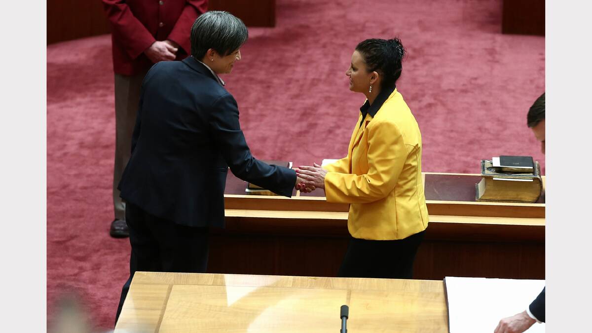 Senator Penny Wong congratulates PUP Senator Jacqui Lambie during the swearing-in of new Senators in the Senate, at Parliament House in Canberra on Monday. Photo: Alex Ellinghausen
