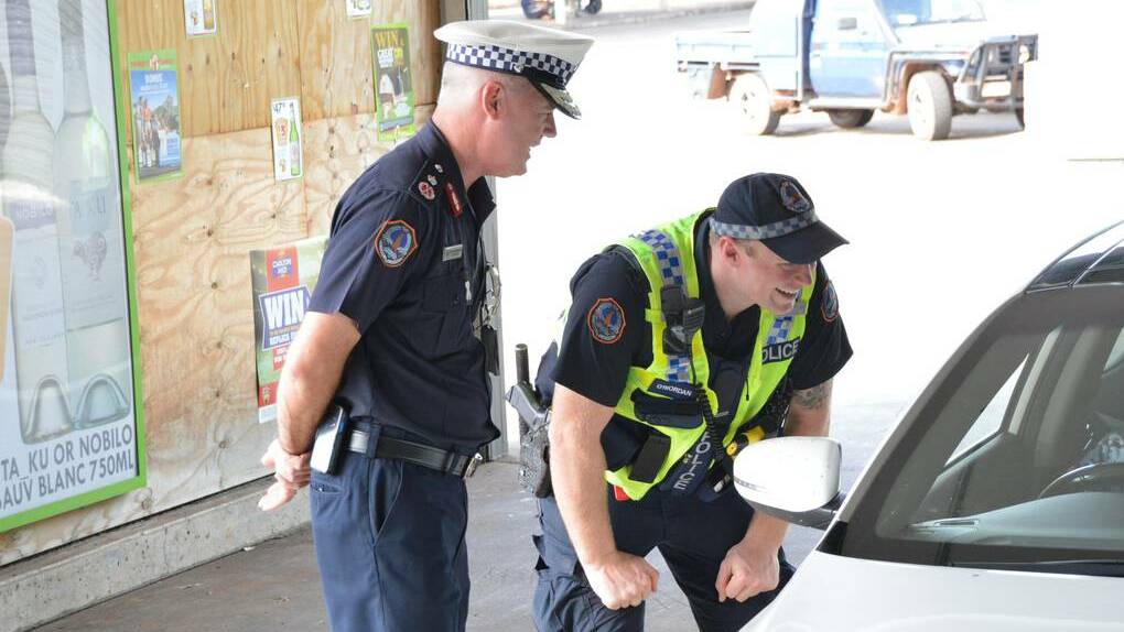 Northern Territory Police Commissioner John McRoberts and Constable First Class David O’Riordan check a bottle shop patron’s licence as part of Katherine’s temporary police beat trial. 