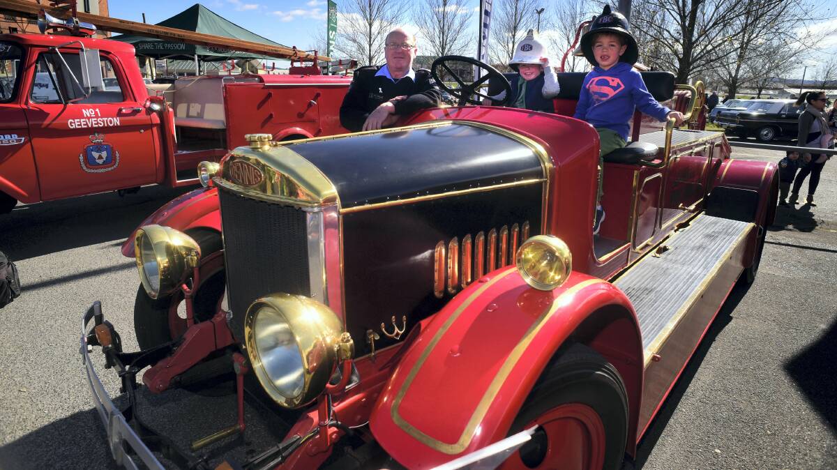 Tasmanian Fire Service district officer John Hazzlewood shows a TFS 1929 Dennis fire truck to Trai Hawksley, 4, of Ravenswood, and Toby Cheney, 7, of Invermay. Picture: PAUL SCAMBLER