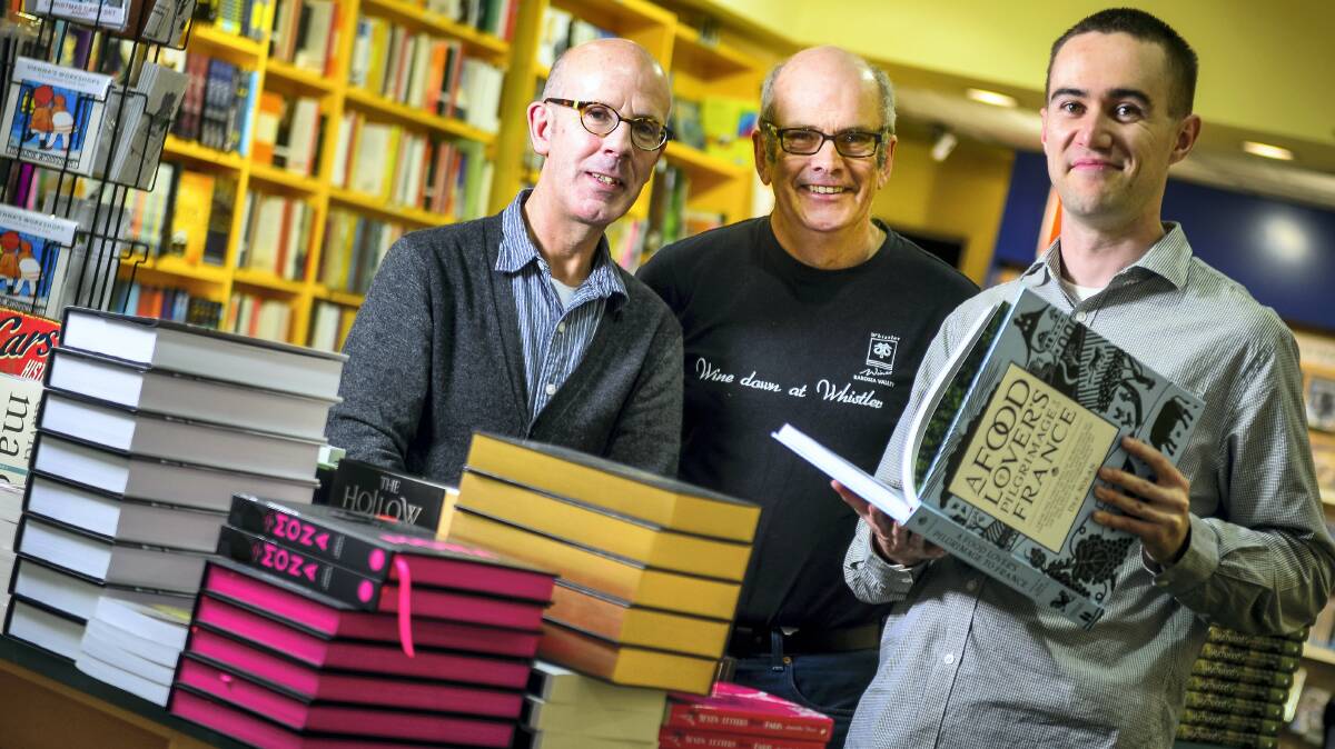 Outgoing Fullers Bookshop Launceston owner Clive Tilsley, centre, with new owners Michael French and Ash Campbell.  Picture: PHILLIP BIGGS