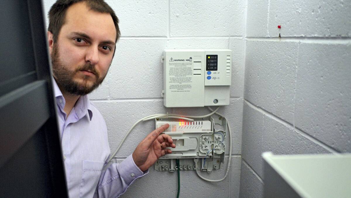 Inerva Enterprise Software designer Travis Purdy with an installed but inactive fibre-optic National Broadband Network unit.