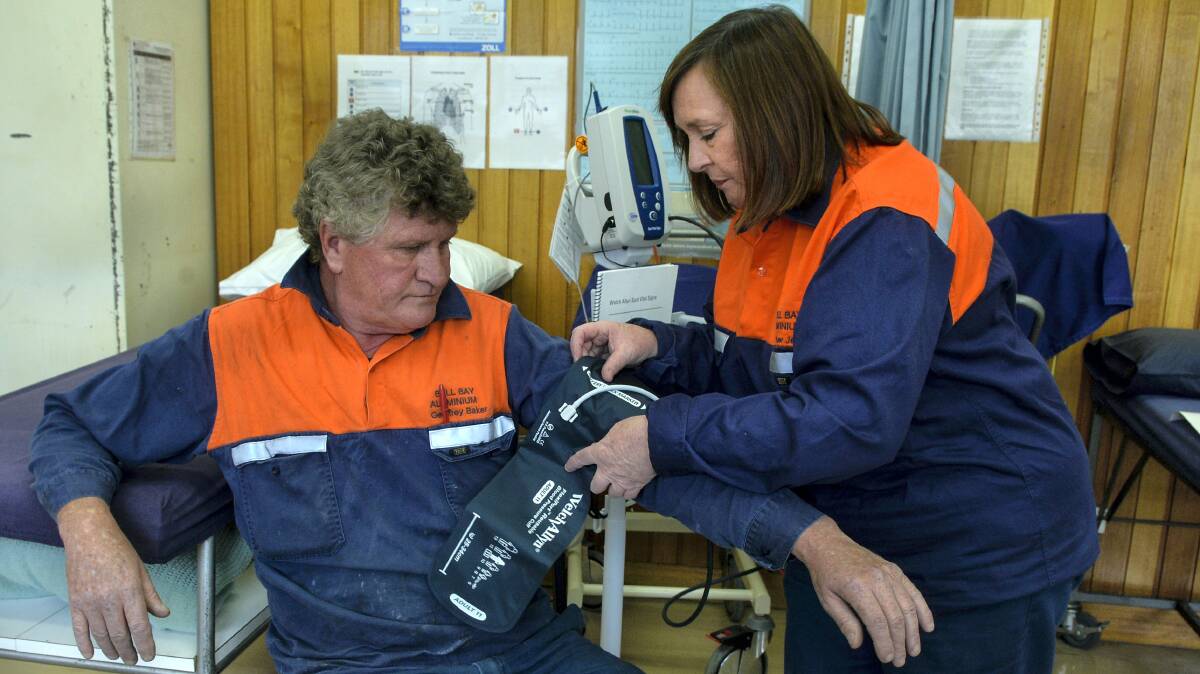 Nurse Heather Jensen takes the blood pressure of Bell Bay Aluminium employee Geoffrey Baker who has had two heart attacks.  Picture: NEIL RICHARDSON