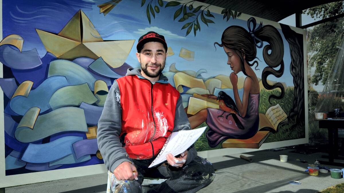 International Mural Fest winner Nikolay Dimitrov, from Bulgaria, with his creation, Traveling Dreams. Picture: GEOFF ROBSON