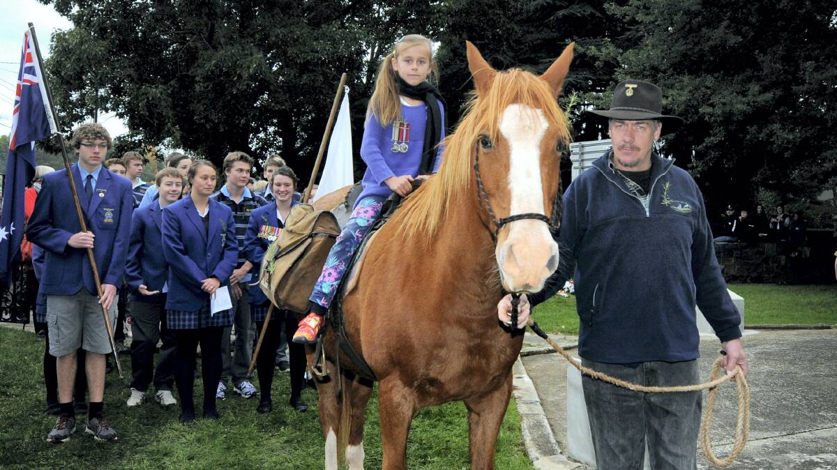 Tony Dixon, of Deloraine, leads Rocky and Gabby Pyka, 7, of Launceston, who rode the horse to yesterday's Deloraine service as a tribute to her late grandmother. Picture: GEOFF ROBSON