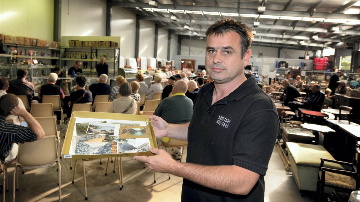 Armitage Auctions employee Andrew Snooks with some early Launceston postcards. Picture: GEOFF ROBSON