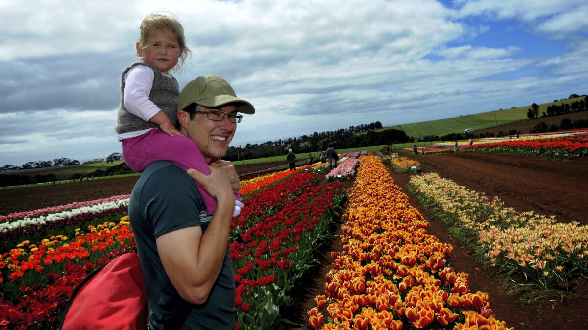 Jordan Taylor, of Natone, with Scarlet, 2, at Wynyard’s Table Cape Tulip Farm. Picture: GEOFF ROBSON