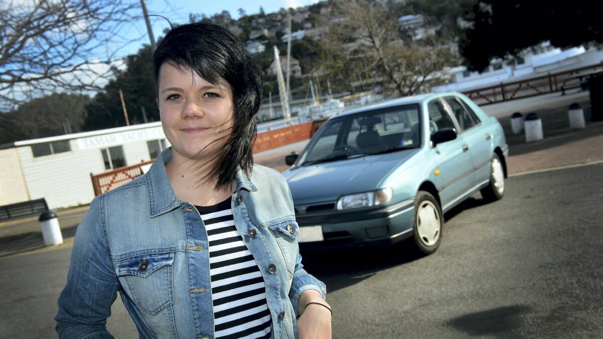 Tessa Wynne, of Launceston, with her 1993 Nissan Pulsar that has been stolen once and broken into repeatedly.  Picture: PAUL SCAMBLER