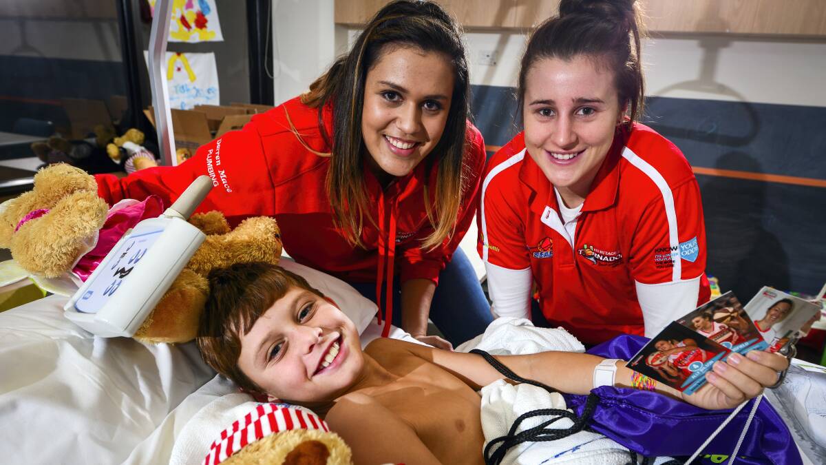 Tornadoes players Ally Wilson and Lauren Mansfield with 11-year-old Launceston General Hospital 4K patient Ryan Butt. Picture: PHILLIP BIGGS