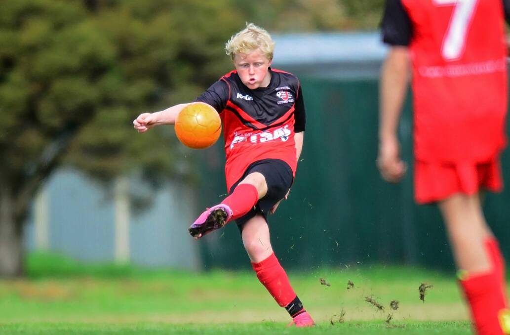 Ulverstone under-12 boys development team's Archer Holling chips the ball forward.