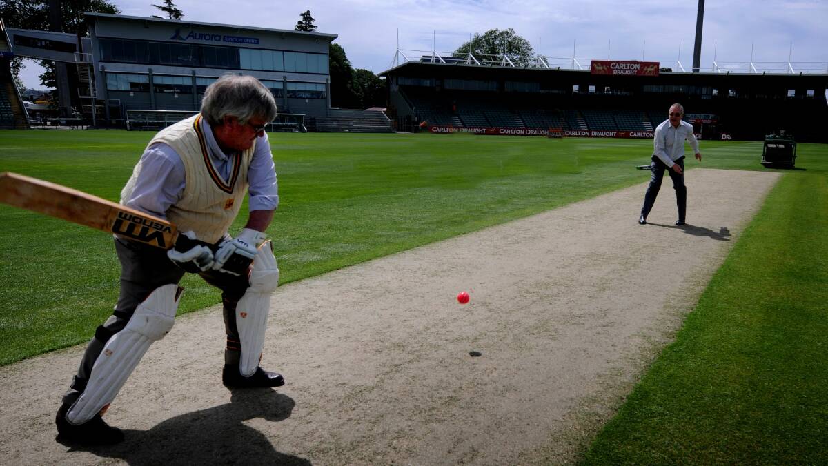 Sticky wicket: Tony Benneworth helps christen the Aurora Stadium drop-in wicket with Launceston City Council general manager Robert Dobrzynski in 2013.