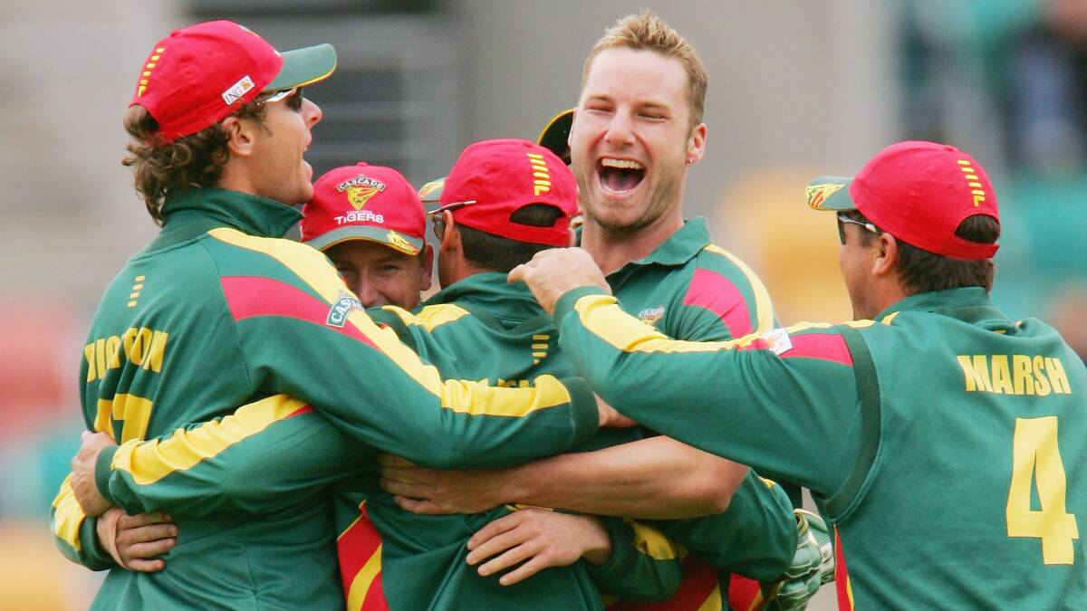 Mateship: Adam Griffith celebrates with Tasmanian teammates, including his predecessor as head coach Dan Marsh, in 2004. Picture: Getty Images