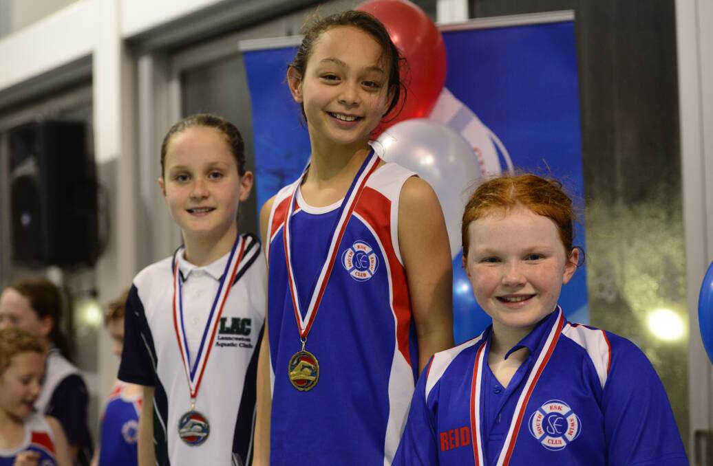 Fly screen: Women's nine and under 50m butterfly medallists Mollie Gray, of LAC, (second), and South Esk's Ella Chan (first) and Alice Reid (third). Pictures: Erica Kreismann