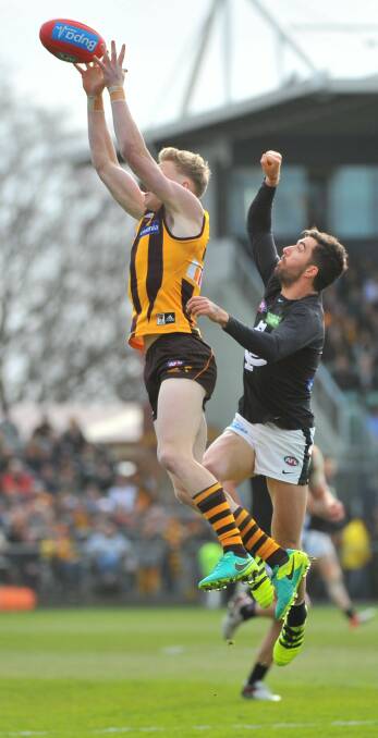 REACHING FOR THE SKIES: Hawk half-forward James Sicily marks strongly in front of Carlton veteran Kade Simpson at Aurora Stadium. Pictures: Scott Gelston