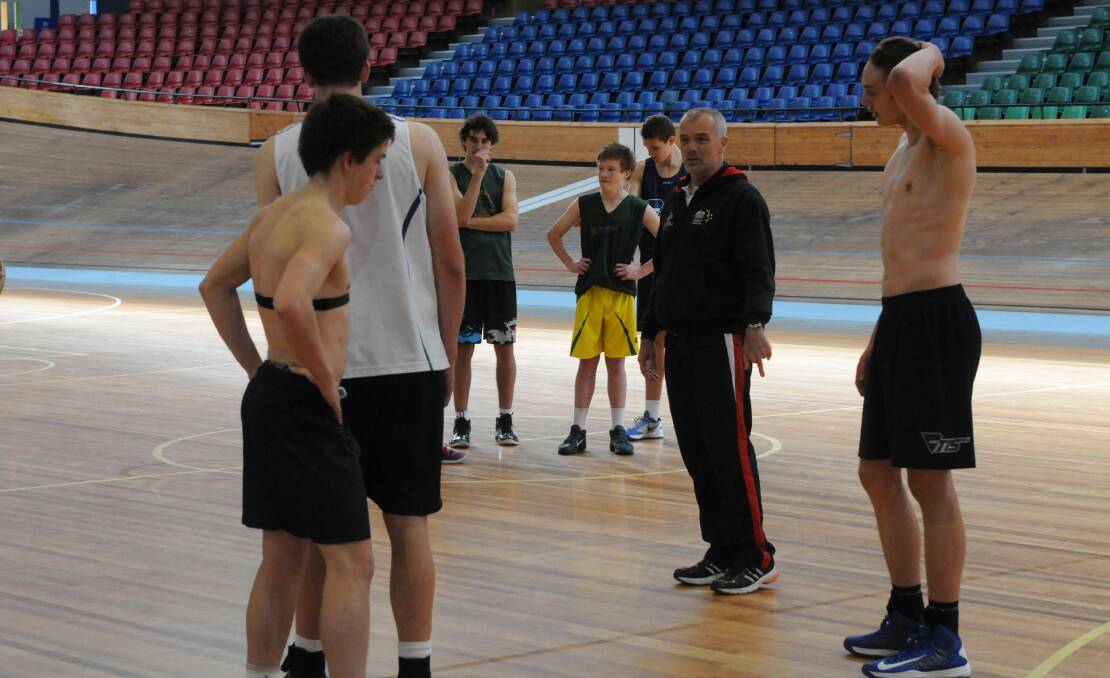 National Basketball coach Ian Stacker in Launceston in 2012 coaching the TIS basketball squad including Kai Woodfall (left) and Kyle Clarke (right).
