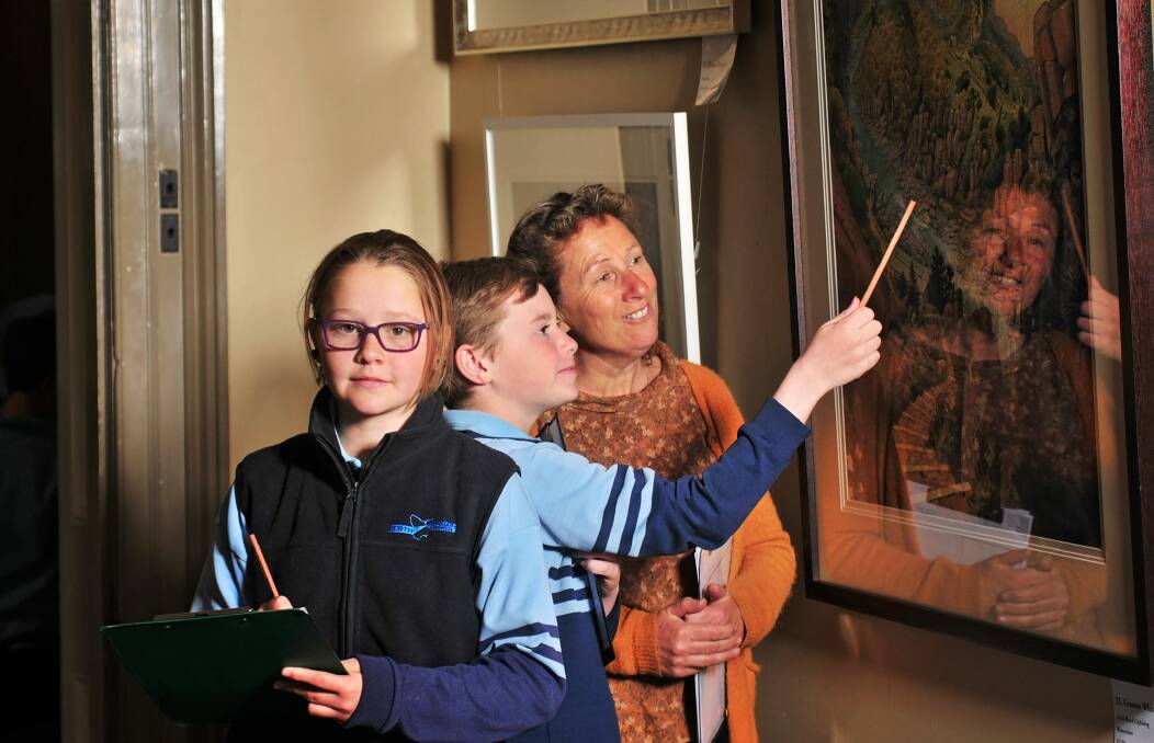 ART: LAS artist Claire Holder discusses a painting by Graeme Whittle with Perth Primary School pupils Jennifer Areynolds and Jack Triffett. Picture: Phillip Biggs