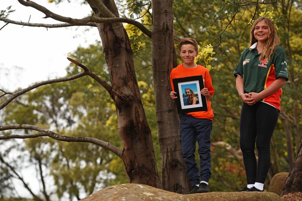 IN HER HONOUR: Bella Dyer, 13, and Codey Ketchell, 12, with a photo of Codey's sister Tahlia Ketchell who died last year. Picture: Scott Gelston