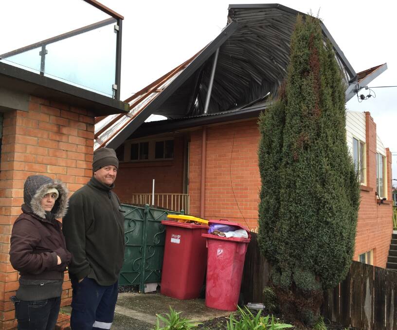 Kings Meadows residents Nellie and Darcy Camm inspect the damage caused to their neighbours roof on Tuesday. Picture: Sarah Aquilina