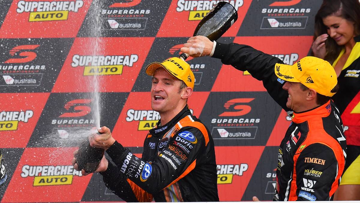 Winners: Holden drivers Will Davison  and Cameron McConville celebrate on the podium after the Bathurst 1000 at Mount Panorama. Photo: Getty Images