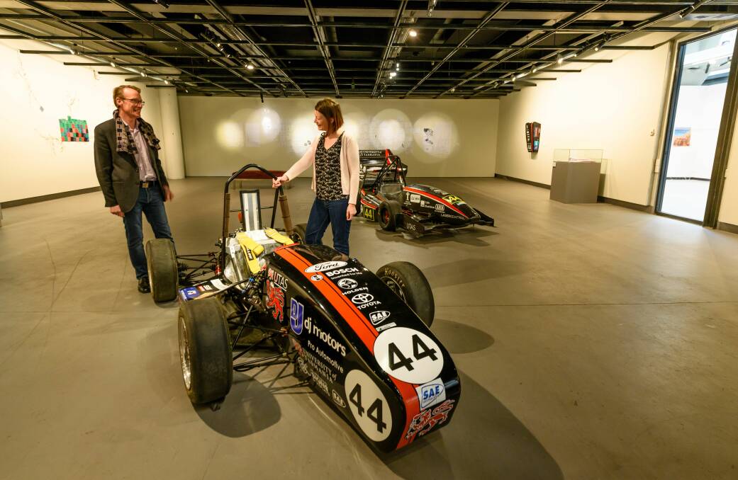 IN THE FAST LANE: University of Tasmania Academy director Malcom Bywaters with gallery volunteer Renee Austin with the F1 cars built as part of a student project. Pictures: Scott Gelston