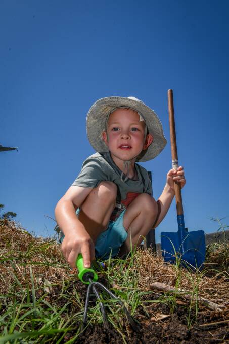 Noah Van der Vlist, 3, tries his hand at gardening at Patersonia early learning centre's bush Kinder, held at the Heritage Forest Community Garden.