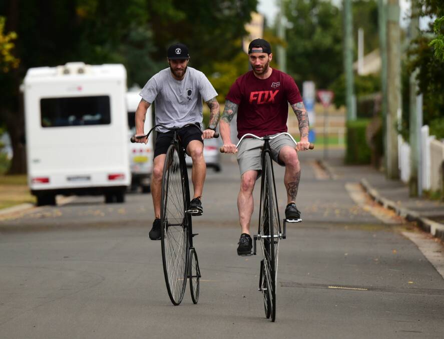 STEADY HANDS: Chris Haffey and Adam Jones, of Nitro Circus, try their hand at riding penny farthings at Evandale. Picture: PAUL SCAMBLER