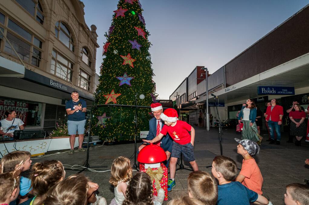 Light it up: Make a Wish kid Henry Thompson pressed the button to light up the Brisbane Street Mall Christmas tree. Picture: Phillip Biggs.