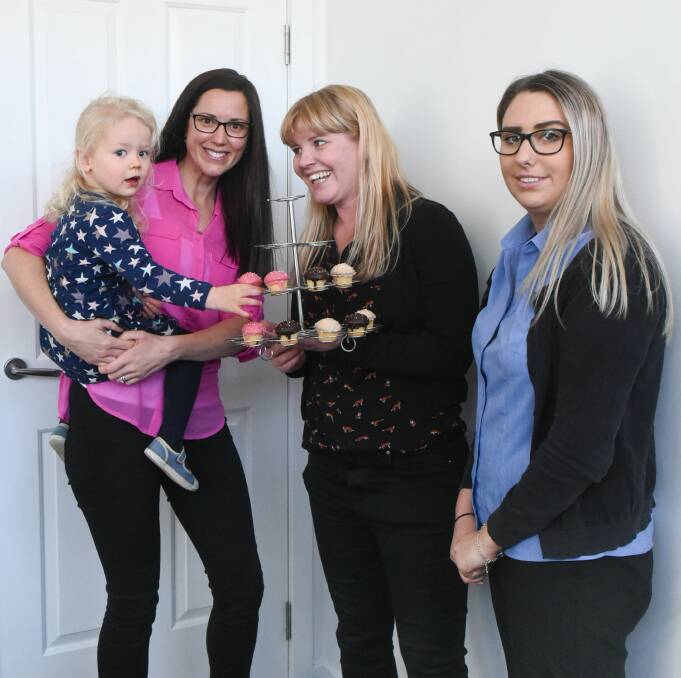 DELICIOUS: Dr Stephanie Kerr with her daughter Philippa, 2, grabs a cupcake from the RSPCA's Melanie Knight and Caledonian Medical Centre's Georgia Hayward ahead of RSPCA's Cupcake Day. Picture: Neil Richardson