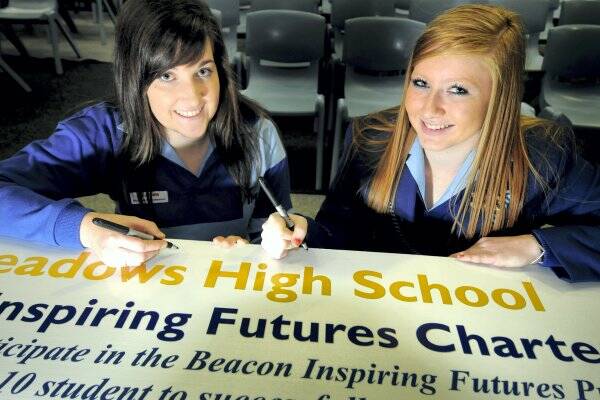 Signing the Beacon Foundation charter yesterday were Kings Meadows students Kaleah Gathercole and Caitlyn Morice. Picture: GEOFF ROBSON