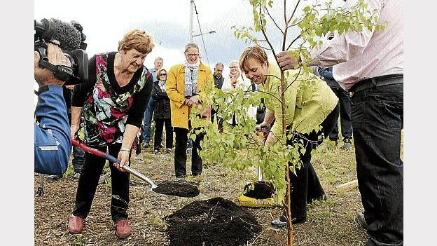 Dunalley resident Judy Young and Premier Lara Giddings plant a commemorative silver birch, the Celtic symbol of new beginnings, at the site of the new community hall one year after devastating fires swept through the region.