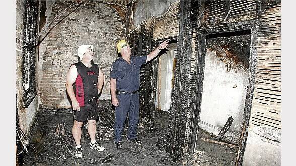 Hotel owner Lee Green and Burnie fire station officer Rob Deverell inspect the damage.