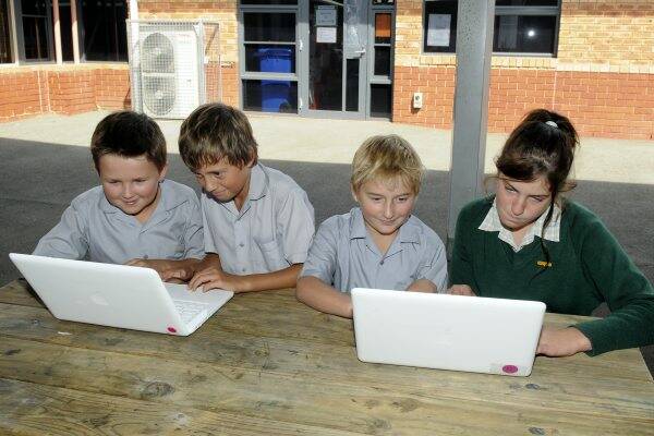 St Finn Barrs grade 5/6 pupils Hayden Kok, 11, Reilly Loone, 11, Jake George, 10, and Jayde Walters, 11, with just two remaining laptop computers following a theft over the weekend.