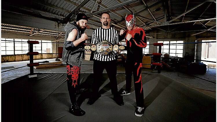 Tasmanian Pro Wrestling Championship organiser Leigh Barber with the championship belt is flanked by contestants Eddie Jones and Diablo.  Picture: GEOFF ROBSON